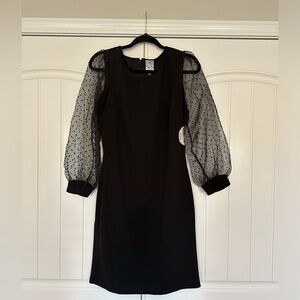 Black mini dress with sheer puff sleeves.